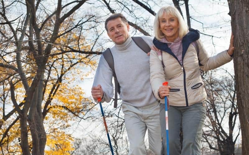 Heureux couple d'âge moyen marchant dans les bois Heureux couple d'âge moyen marchant dans les bois